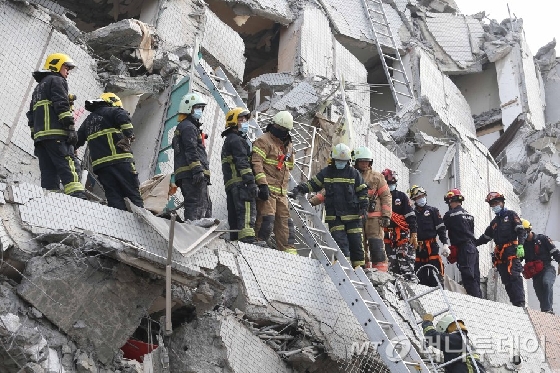 타이난시의 무너진 건물에서 구조대가 사다리를 이용해 인명 구조에 나서고 있다.  <br>
