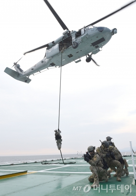 18일(목) 오전 동해상에서 열린 해군·해경 합동 해상대테러 훈련에서 해군 특수전전단(UDT/SEAL) 대테러팀이 해군 UH-60 헬기에서 해경 제민12호(피랍 상선 모사) 함미 헬기갑판으로 공중 침투하고 있다./사진=해군 제공
