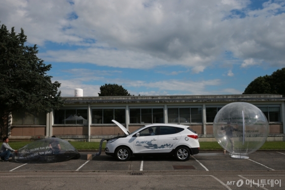 6월 4일 프랑스 그르노블에 위치한 에어리퀴드사 기술연구소에서 투싼ix 연료전지차를 이용해 오염된 공기(왼쪽 풍선)를 깨끗한 공기(오른쪽 풍선)로 정화하고 있다. /사진제공=현대자동차 