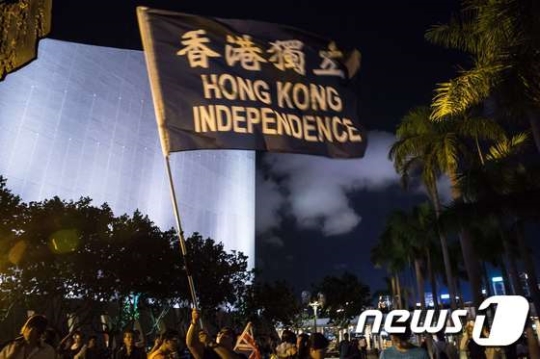 이달 4일 홍콩 참샤추이에서 열린 '천안문사태 27주년' 시위에서 한 참가자가 '홍콩 독립'이 적힌 깃발을 흔들고 있다./AFPBBNews=뉴스1