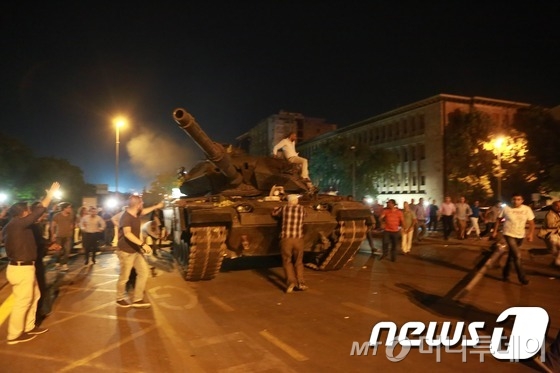 터키 군부의 쿠데타 시도에 항의하는 시민들이 16일 수도 앙카라 시내에서 쿠데타 군의 탱크에 오르고 있다. © AFP=뉴스1