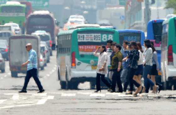 아지랑이가 피어 오르는 서울 여의도공원 앞 횡단보도에서 시민들이 발걸음을 재촉하고 있다./사진=뉴스1
