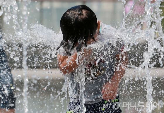 전국 기온이 37도까지 올라가 폭염특보가 발효됐던 8월11일 오후 서울 광화문 광장 분수에서 한 어린이가 더위를 피해 물을 맞고 있다/사진=김창현 기자<br>
