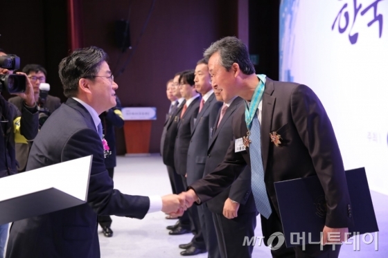 이용성(사진 오른쪽) 한글라스 대표가 한국에너지효율대상 은탑산업훈장을 받은 뒤 정승일 산업통상자원부 에너지자원실장과 악수하고 있다/사진제공=한글라스 