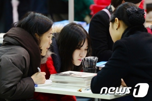 한국대학교육협의회가 지난해 12월 개최한 '2016학년도 정시 대학입학정보박람회'에서 한 수험생과 학부모가 입학상담을 받고 있다. /뉴스1 © News1