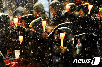 눈이 내린 21일 오후 전북 전주시 충경로 사거리에서 열린 전북도민총궐기 참가자들이 눈을 맞으며 촛불을 들고 있다.2017.1.21/뉴스1 © News1 문요한 기자