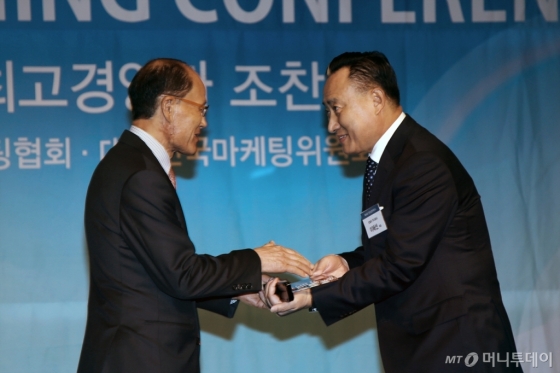 이해선 코웨이 대표이사(오른쪽)가 19일 한국마케팅협회 신임 회장 취임식에서 원대연 한국마케팅협회 명예회장(왼쪽)으로부터 위촉패를 받고 있다./사진제공=코웨이