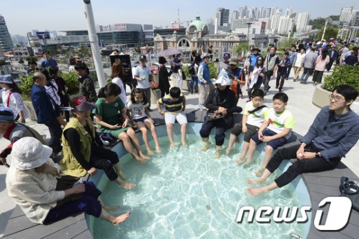 20일 오전 국내 최초의 공중보행로로 재거듭난 '서울로 7017'에서 시민들이 족욕을 하며 휴식을 취하고 있다. /사진제공=뉴스1