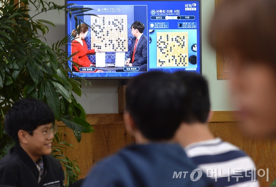 중국 바둑랭킹 1위인 커제 9단과 구글 인공지능(AI) 바둑프로그램 알파고의 첫 대결이 펼쳐진 23일 오후 서울 성동구 행당동 이세돌바둑연구소에서 원생들이 텔레비전 중계를 보며 바둑을 두고 있다. 사진= 뉴스1