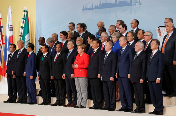  주요 20개국(G20) 정상회의에 참석한 각국 정상들과 국제기구 수장들이 7일(현지시간) 독일 함부르크 행사장에서 단체로 기념사진을 촬영했다. 문재인 대통령은 사진 맨 오른쪽에 서 있다. 문 대통령 옆으로는 (우에서 좌로) 미셰우 테메르 브라질 대통령, 레제프 타이이프 에르도안 터키 대통령, 블라디미르 푸틴 러시아 대통령, 시진핑 중국 국가 주석, 앙겔라 메르켈 독일 총리 등이 서 있다.    © 로이터=뉴스1 