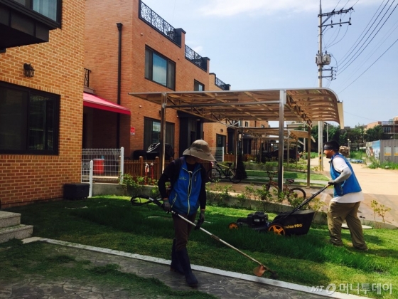 신축 임대주택 앞 잔디를 관리업체 직원들이 손질하고 있다. /사진=남궁민 기자