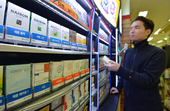  정부가 담뱃값 인상 효과를 발표한 7일 한 서울시내 편의점에서 고객이 담배를 고르고 있다.  기획재정부 발표에 따르면 지난해 담배 판매량은 직전년도 대비 23.7%(10억3000갑) 줄어든 33억3000갑, 담배 세수는 10조5000억원으로 직전년도 대비 3조6000억원 증가한 것으로 집계됐다. 이는 세수는 3조6000억 증가, 판매량은 24% 감소한 수치다. 2016.1.7/뉴스1  <저작권자 © 뉴스1코리아, 무단전재 및 재배포 금지>