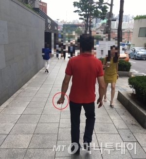 서울 중구 서울스퀘어 인근 도로에서 한 남성이 걸어가며 담배를 피우고 있다./사진=남형도 기자