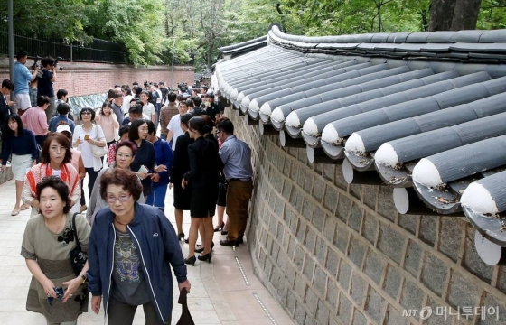 1959년 영국대사관의 점유로 60여 년간 철문으로 막혀 일반인의 통행이 제한됐던 덕수궁 돌담길 100m 구간을 보행길로 정식 개방한 30일 오전 서울 영국대사관 신규후문 앞에서 시민들이 돌담길을 걷고 있다.