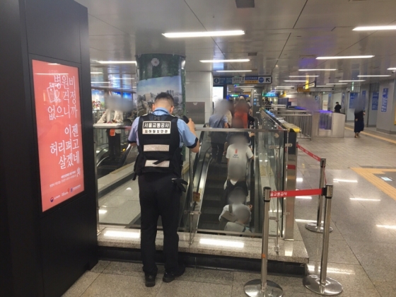 지하철 보안관이 8월31일 오전 서울역 에스컬레이터에서 몰카를 적발하기 위해 살펴보고 있다./사진=남형도 기자