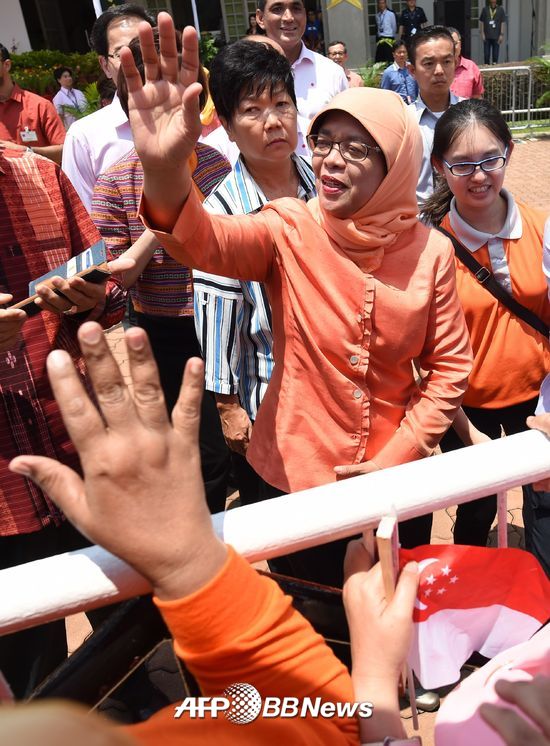 싱가포르 첫 여성 대통령으로 당선된 할리마 야콥이 13일 싱가포르 시내에서 지지자들에게 손을 흔들고 있다./AFPBBNews=뉴스1