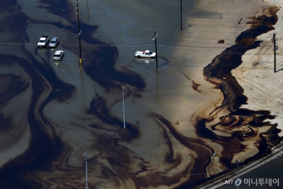 8월 31일 (현지시간) 허리케인 하비가 강타한 텍사스 주 포트아서의 정유회사 모티바엔터프라이즈 주차장에 물과 섞인 기름이 누출된 모습이 보인다. /사진= © 로이터=뉴스1