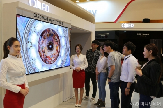 IMID 2017에 참가한 관람객들이 LG디스플레이 부스에서 77인치 UHD 월페이퍼 OLED를 감상하고 있는 모습/사진=LG디스플레이