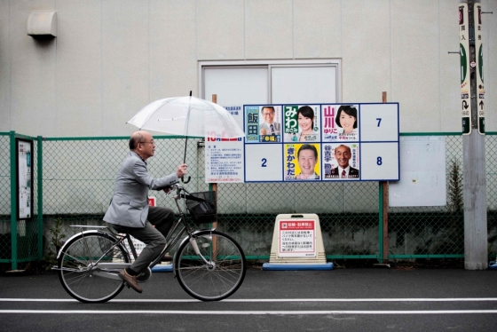 지난 20일 일본 사이타마현 고시가야시에서 한 남성이 자전거를 타고 오는 22일 진행되는 중의원 선거에 출마한 후보 소개 포스터 앞을 지나고 있다. /AFPBBNews=뉴스1