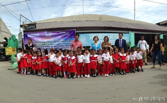 17일(현지시간) 필리핀 앙헬레스 사방가토바랑가이 아동센터에서 열린 아동센터 및 직업학교 증축식에서 현지 아이들이 기념촬영을 하고 있다. /사진제공=현대로템.