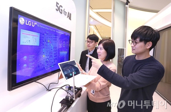 사진은 LG유플러스 직원들이 5G의 빠른 반응 속도를 보여주는 ‘5G 진동추’를 시연해 보고 있는 모습/사진제공=LGU+