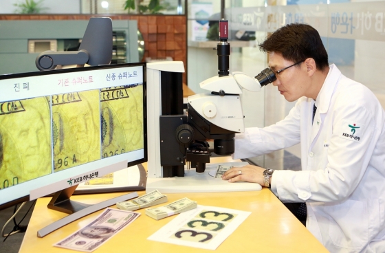 KEB하나은행 위변조대응센터 직원이 전자 현미경을 통해 미국 달러화 지폐의 진폐 여부를 감별하고 있다. / 사진제공=KEB하나은행