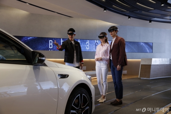 '비트(BEAT) 360'에서 세계 최초로 홀로 렌즈 매개 현실(MR) 기술을 활용해 차량의 특장점을 설명하는 '디지털 도슨트 투어' 프로그램을 고객들이 체험하고 있다./사진제공=기아차 