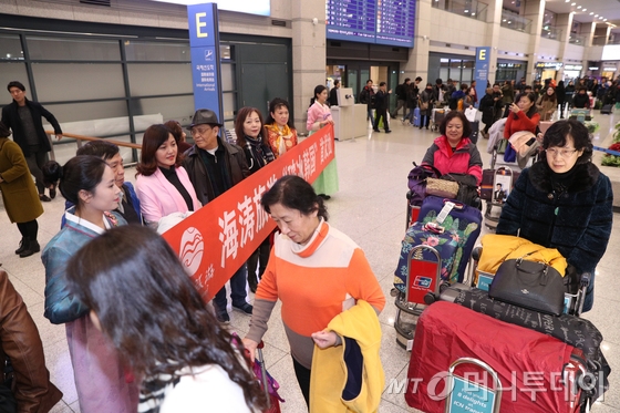  2일 오후 인천국제공항을 통해 방한한 중국인 단체관광객들이 손을 흔들며 공항을 나서고 있다.  이들은 한국과 중국의 고고도 미사일 방어체계(THAAD·사드) 갈등으로 지난 3월 한국행 단체 관광이 중단된 이후 처음으로 찾는 중국인 단체 관광객이다. 2017.12.2/뉴스1  <저작권자 © 뉴스1코리아, 무단전재 및 재배포 금지>