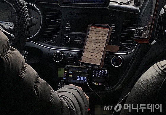 서울에서 운행 중인 한 택시 미터기 위에 가상화폐거래소 애플리케이션이 구동되는 스마트폰이 거치돼 있다. /사진=신현우 기자
