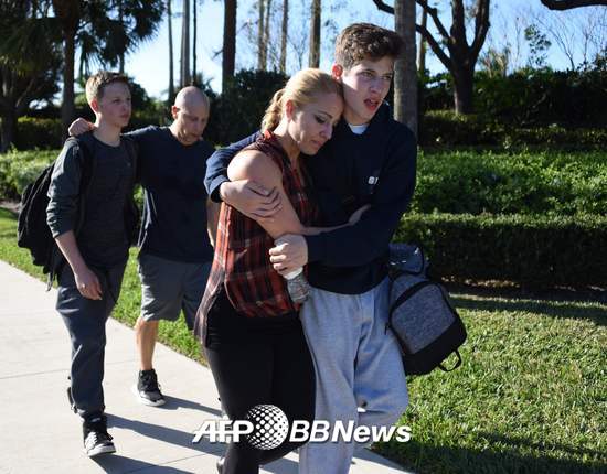 14일(현지시간) 미국 플로리다주 마이애미에서 북쪽으로 72km 떨어진 파크랜드에 있는 마조리 스톤맨 더글라스 고등학교에서 17명이 사망하는 총기난사 사건이 발생했다. 총격범이 경찰에 체포된 이후 학생들이 부모들과 함께 귀가하고 있는 모습. /AFPBBNews=뉴스1