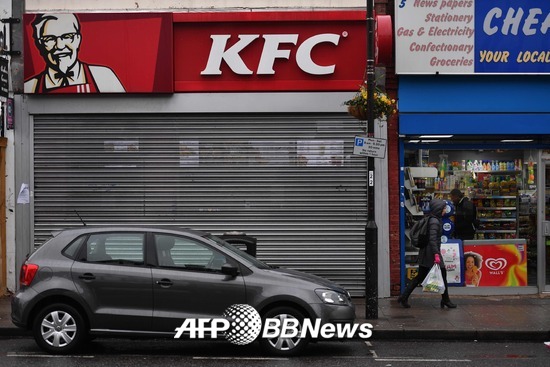 영국 런던에서 한 시민이 19일(현지시간) 문이 닫긴 KFC 매장을 앞을 지나고 있다. /AFPBBNews=뉴스1