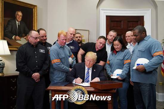 도널드 트럼프 미국 대통령이 8일(현지시간) 워싱턴DC 백악관 집무실에서 철강 노동자 등이 지켜보는 가운데 수입산 철강·알루미늄에 고율의 관세를 물리는 명령에 서명하고 있다./AFPBBNews=뉴스1