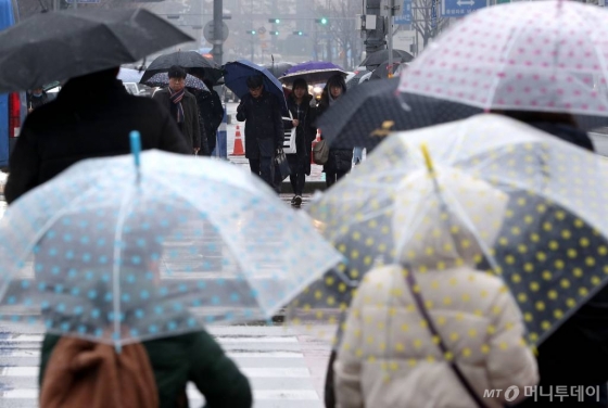 전국 곳곳에 눈, 비가 내리는 오후 서울 광화문 네거리에서 시민들이 우산을 쓴 채 발걸음을 재촉하고 있다.
