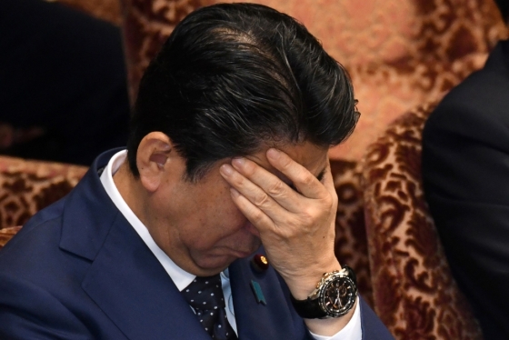 지난 14일 열린 일본 참의원(상원) 예산위원회 회의에서 아베 신조 일본 총리가 모리토모학원의 국유지 헐값 매입과 재무성의 문서조작 파문에 대한 야당의 지적이 계속되자 곤란한 듯 손으로 얼굴을 가리고 있다. /AFPBBNews=뉴스1