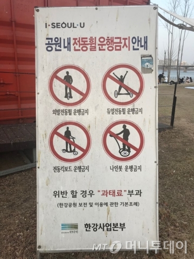 한강 공원 내에서 전동 휠을 탈 수 없다는 표지판이 곳곳에 설치돼 있지만 무용지물이다./사진=한지연 기자