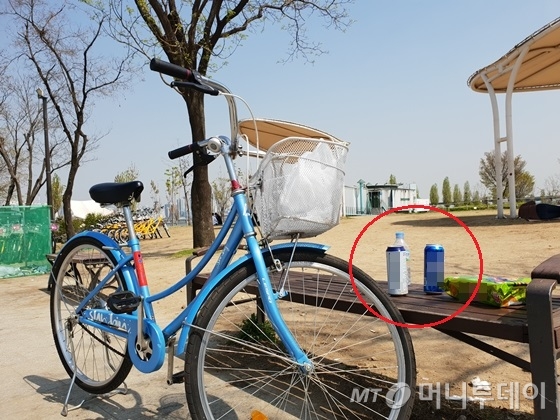 자전거족이 자리했던 곳에 맥주캔과 과자가 남아 있다. /사진=신현우 기자