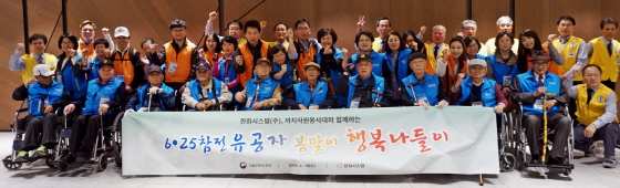 한화시스템 직원들이 18일 서울 여의도 인근에서 6.25 참전 국가유공자들과 함께 즐거운 봄나들이 시간을 갖고 기념촬영을 하고 있다/사진제공=한화시스템