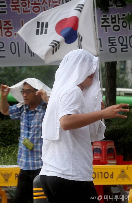서울 청계천 앞을 지나는 시민들이 갑자기 내리는 소나기에 발걸음을 재촉하고 있다./사진=머니투데이