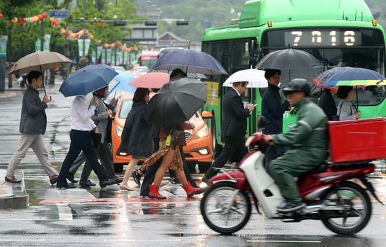 서울 종로구 광화문네거리에서 우산을 쓴 시민들이 발걸음을 재촉하고 있다/사진=뉴스1  
