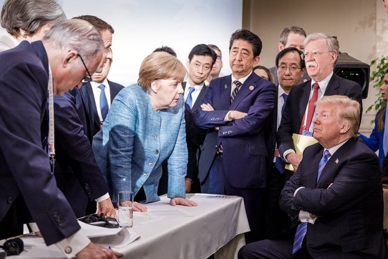 앙겔라 메르켈 독일 총리가 9일(현지시간) 캐나다 퀘벡 주 샤를부아에서 열린 G7 정상회의에서 도널드 트럼프 미국 대통령에게 얘기하고 있다. 좁은 테이블을 사이에 두고 팔짱을 끼고 의자에 앉아 얘기를 듣고 있는 트럼프 대통령과 탁자 위에 손을 올린 채 그를 설득하려는 메르켈 총리, 트럼프 대통령의 발언을 재촉하는 에마뉘엘 마크롱 프랑스 대통령, 팔짱을 낀 채 지루한 표정을 짓고 있는 아베 신조 일본 총리 등의 모습이 G7의 분열상을 적나라하게 드러내는 듯하다. /AFP=뉴스1