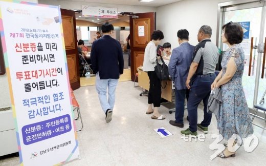제7회 전국 동시 지방선거 및 교육감 선거, 국회의원 재·보궐 선거일인 13일 서울 강남구 청담동 주민센터에 마련된 투표소에서 유권자들이 줄지어 서 있다.