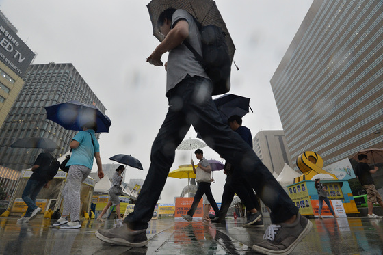 지난해 7월 서울 광화문 네거리에서 우산을 쓴 시민들이 출근길을 재촉하고 있다./사진=뉴스1