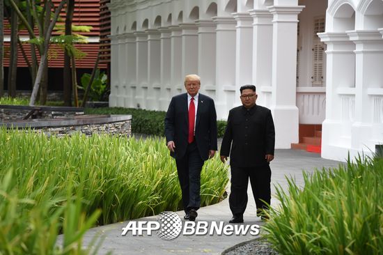 도널드 트럼프 미 대통령(왼쪽)과 김정은 북한 국무위원장이 12일 사상 첫 북미 정상회담이 열린 싱가포르 카펠라 호텔에서 오찬을 함께 한 후 산책하고 있다. /AFPBBNews=뉴스1
