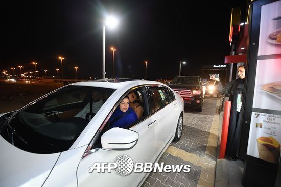 24일(현지시간) 사우디아라비아가 여성의 운전을 처음으로 허용한 가운데 수도 리야드에서 한 여성 운전자가 드라이브스루 음식점에 들러 주문을 하고 있다.  /AFPBBNews=뉴스1