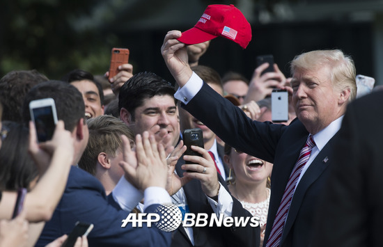 도널드 트럼프 미국 대통령이 지난해 9월 백악관에서 지지자들에게 자신의 상징 중 하나인 '빨간 모자'를 꺼내 흔들고 있는 모습. /AFPBBNews=뉴스1