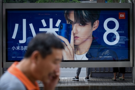 지난 9일 한 남성이 중국 베이징의 한 버스정류장에 설치된 스마트폰 제조업체 샤오미의 광고판 앞을 지나고 있다. /AFPBBNews=뉴스1