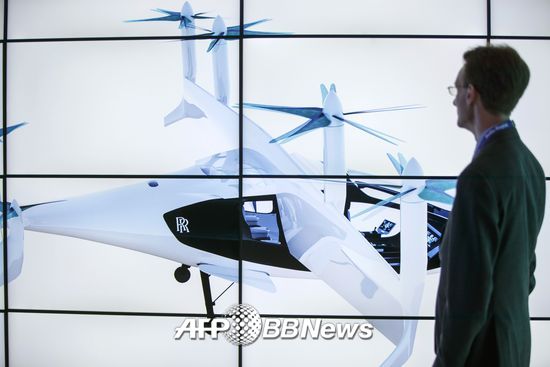 17일(현지시간) 한 남성이 영국 판보로 국제 에어쇼에서 롤스로이스가 공개한 수직이착륙형 비행택시 디자인을 감상하고 있다. /AFPBBNews=뉴스1