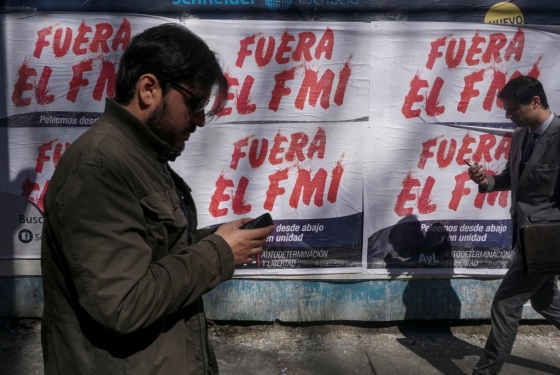 지난 4일(현지시간) 아르헨티나 부에노스아이레스에서 시민들이 IMF(국제통화기금) 지원을 반대하는 포스터 앞을 지나고 있다. /AFPBBNews=뉴스1