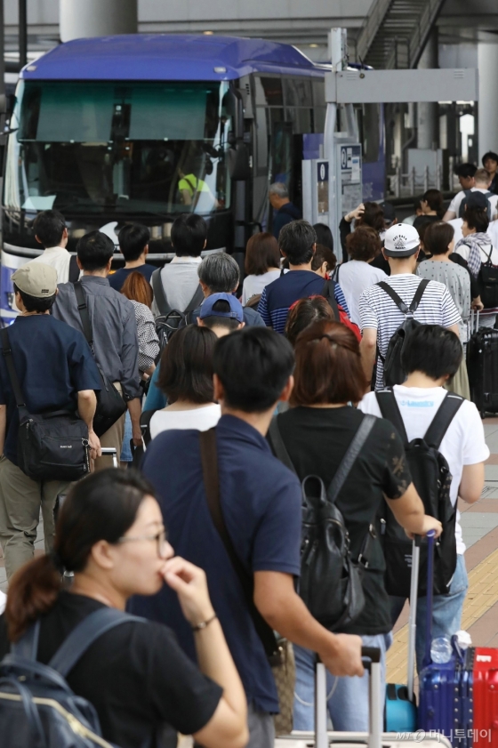 6일 태풍 '제비'가 강타한 일본 간사이공항에 발이 묶였던 여행객이 이즈미사노 시로 이동하기 위해 특별 수송 버스를 타고 있다. © AFP=뉴스1