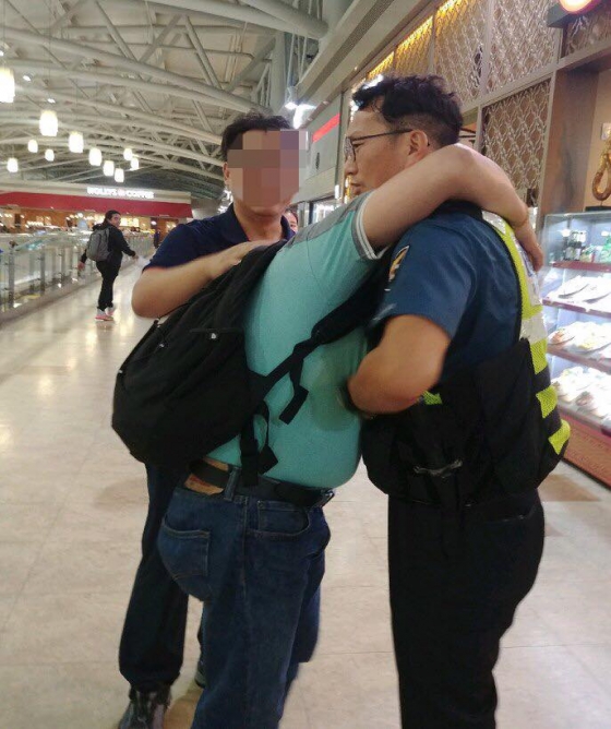 지난 21일 부산 김해공항에서 현금과 선물이 든 가방을 되찾고 감격해 경찰관을 안고 우는 이주노동자 A씨 /사진=부산경찰 페이스북